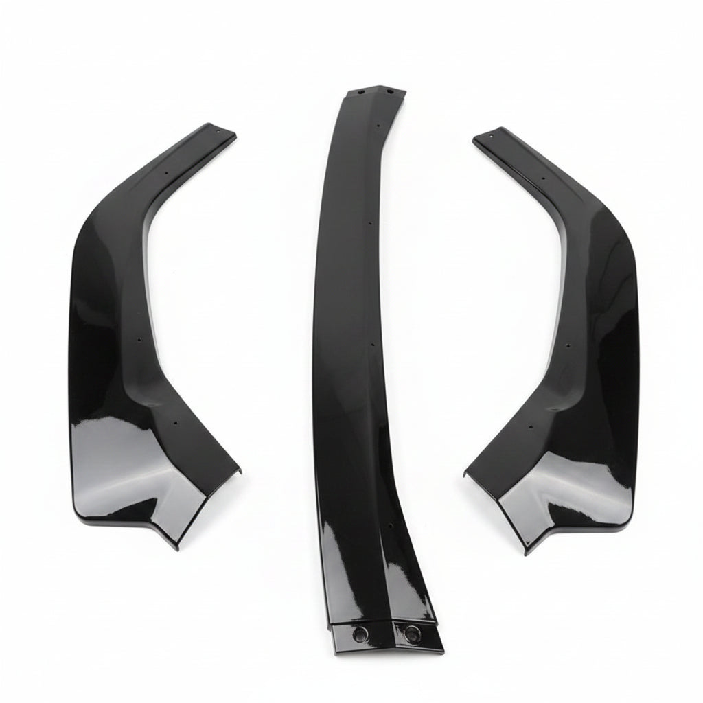 Three glossy black automotive body panels or trim pieces laid flat on a light gray textured fabric background.