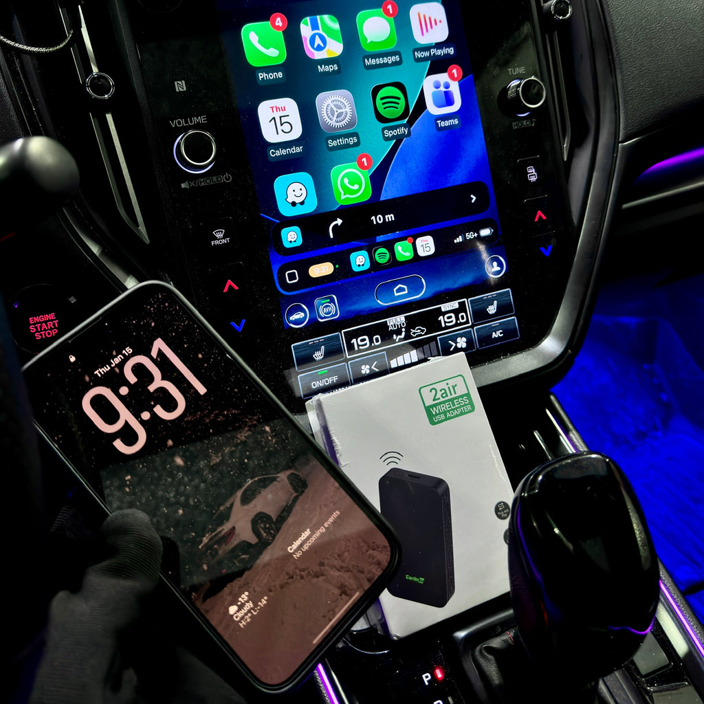 Car dashboard with digital clock, smartphone, and car infotainment system.