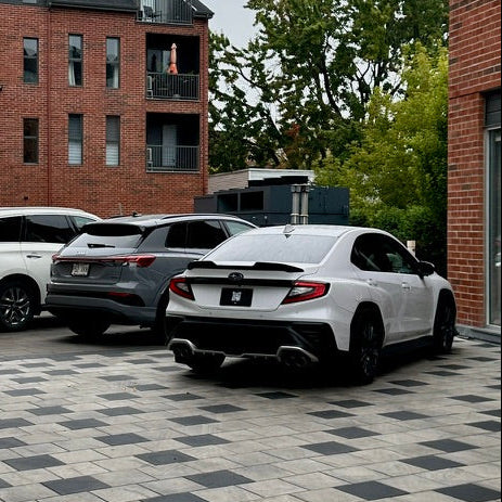 Parking lot with cars in front of a brick building on a cloudy day