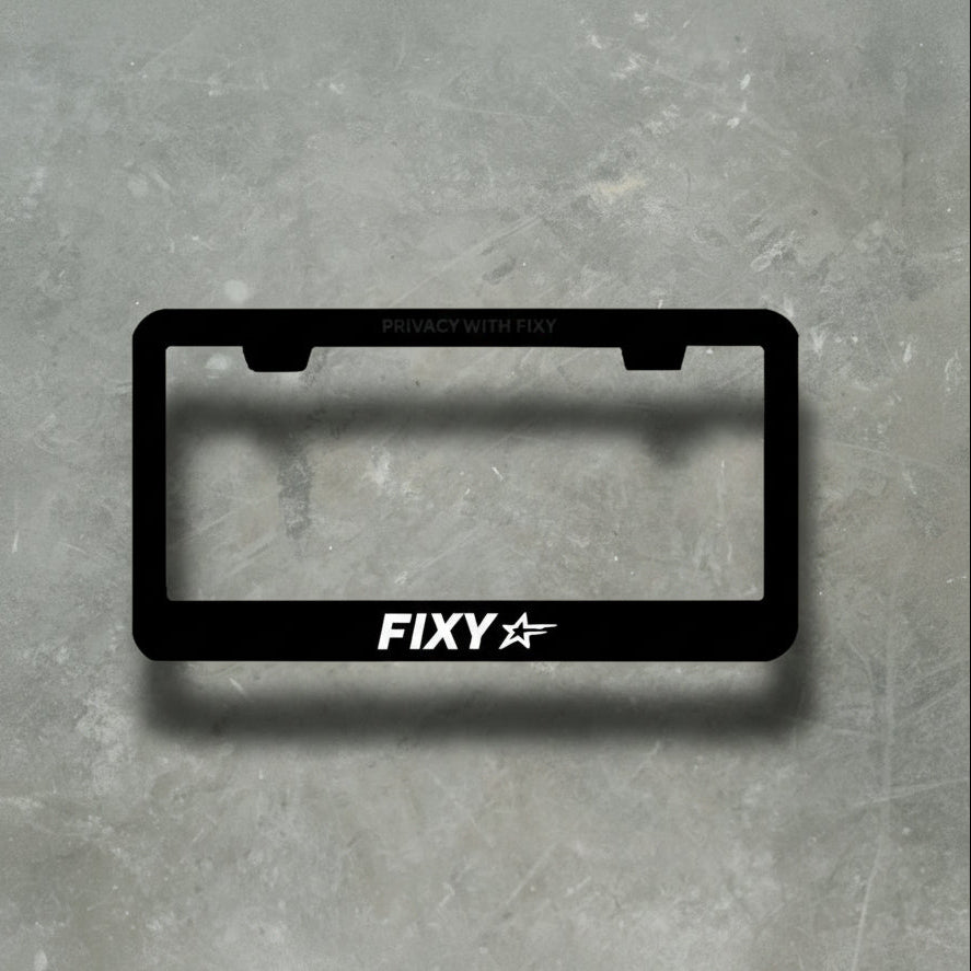 Black license plate frame with 'FIXY' branding on a gray textured background
