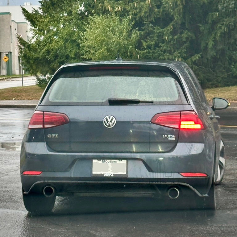 Volkswagen GTI car on a road with trees in the background