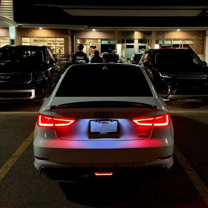 Car with illuminated brake lights in a parking lot at night