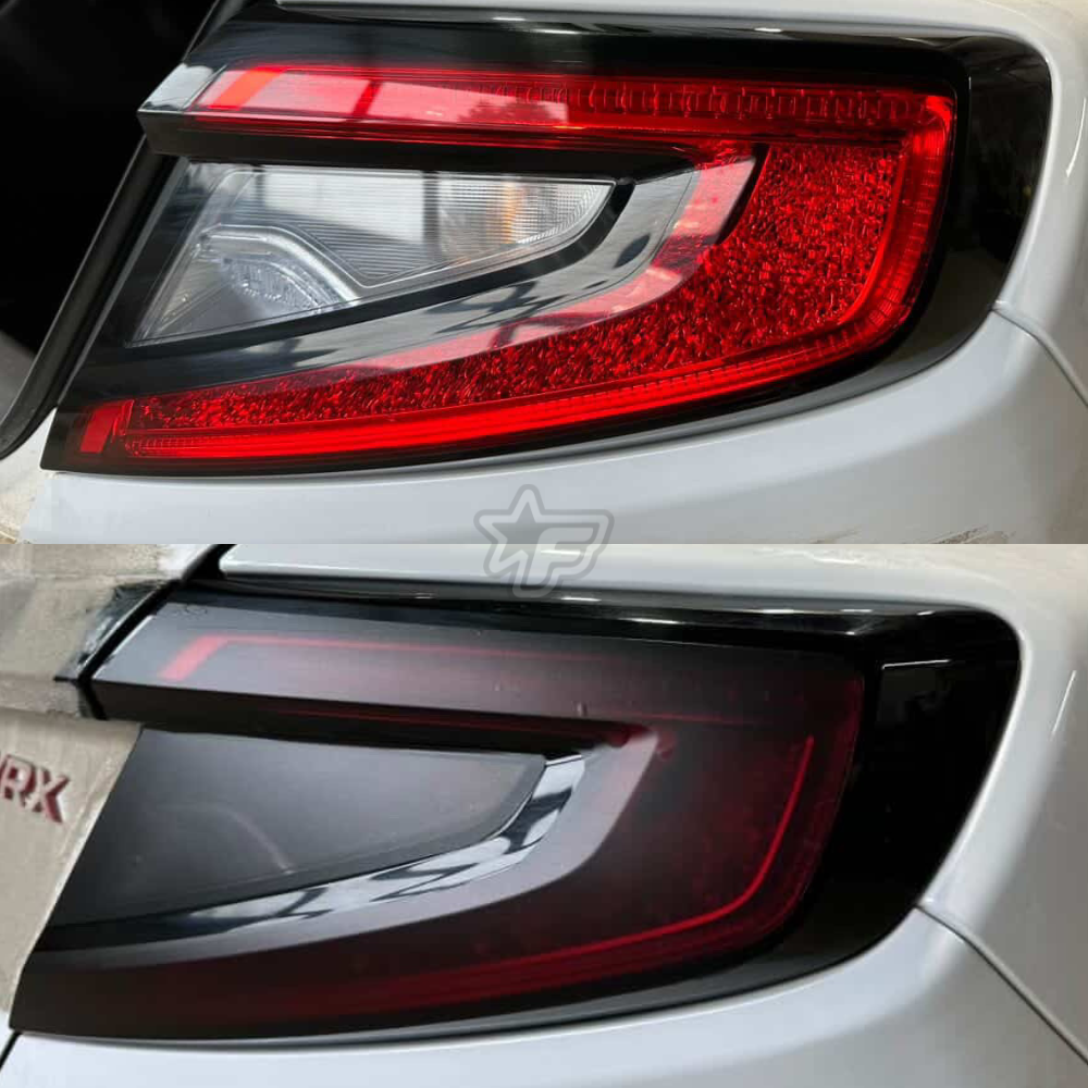 Close-up of a car's red taillight with a visible brand logo.