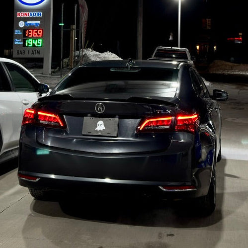 Two cars parked at a gas station with Esso branding at night.