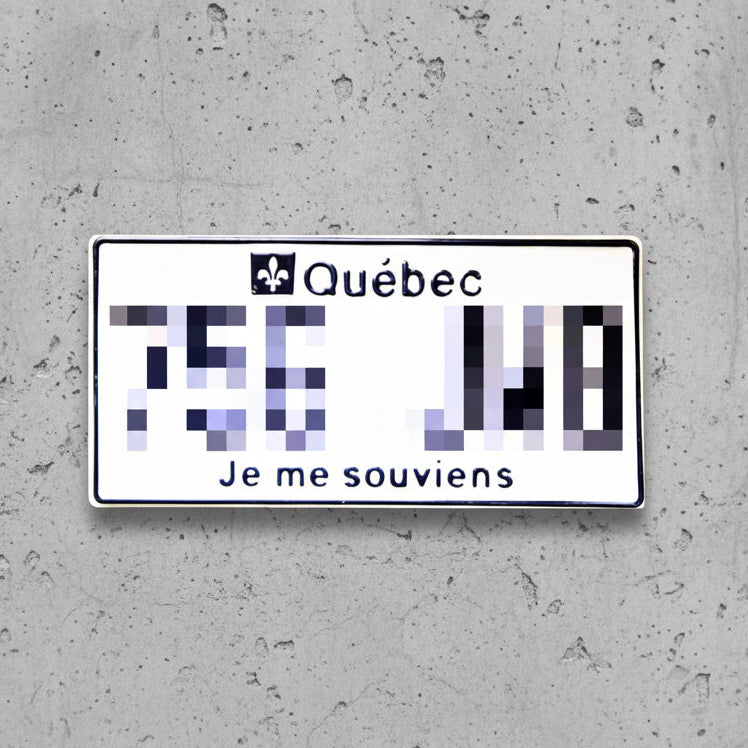 A Quebec novelty license plate sticker or decal with a white background, black border, the word 'Québec' and a fleur-de-lis, pixelated numbers, and the text 'Je me souviens' at the bottom.