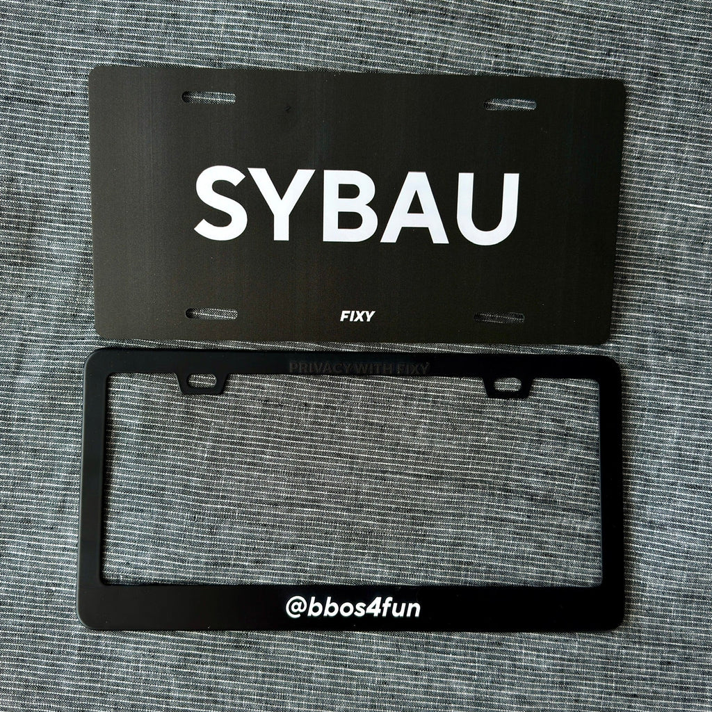 Black license plate with 'SYBAU' text on a gray textured background