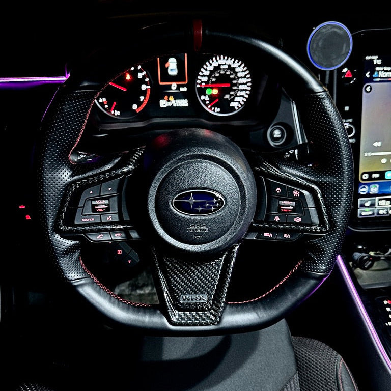 Steering wheel and dashboard of a car with visible Subaru logo