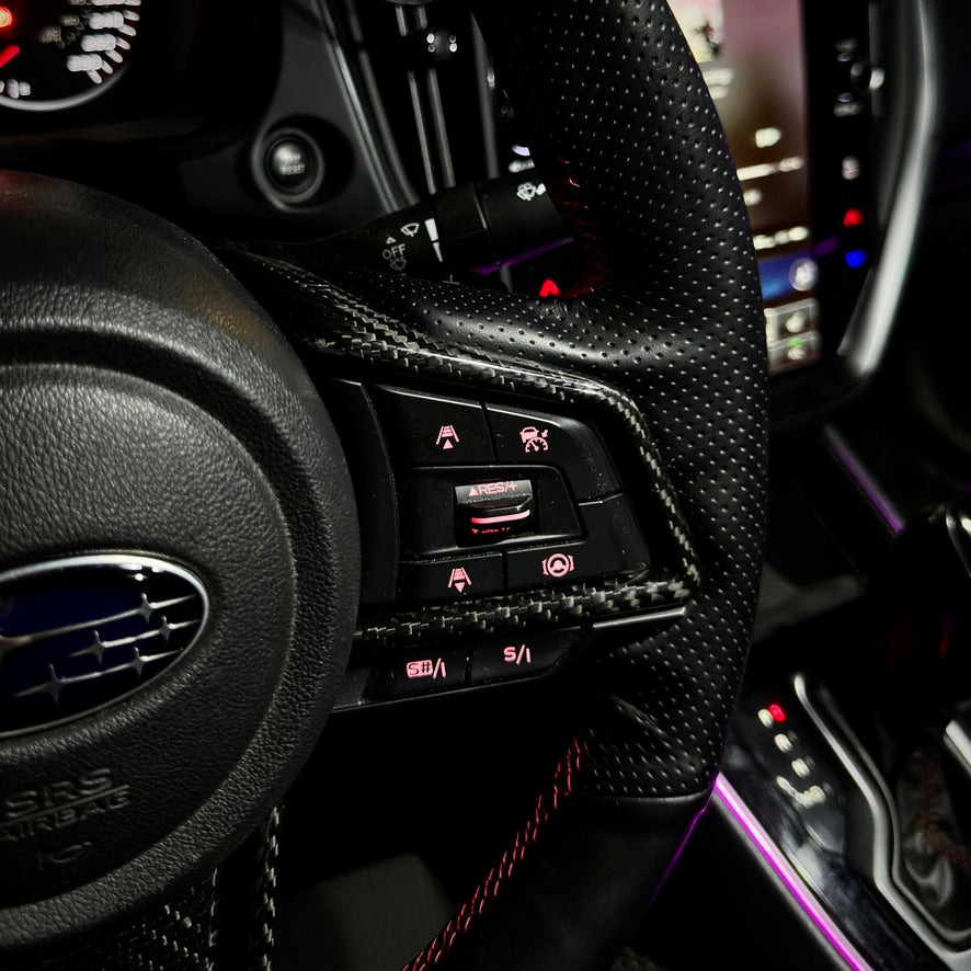 Close-up of a car's interior dashboard with controls and steering wheel.