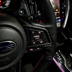 Close-up of a car's interior dashboard with controls and steering wheel.