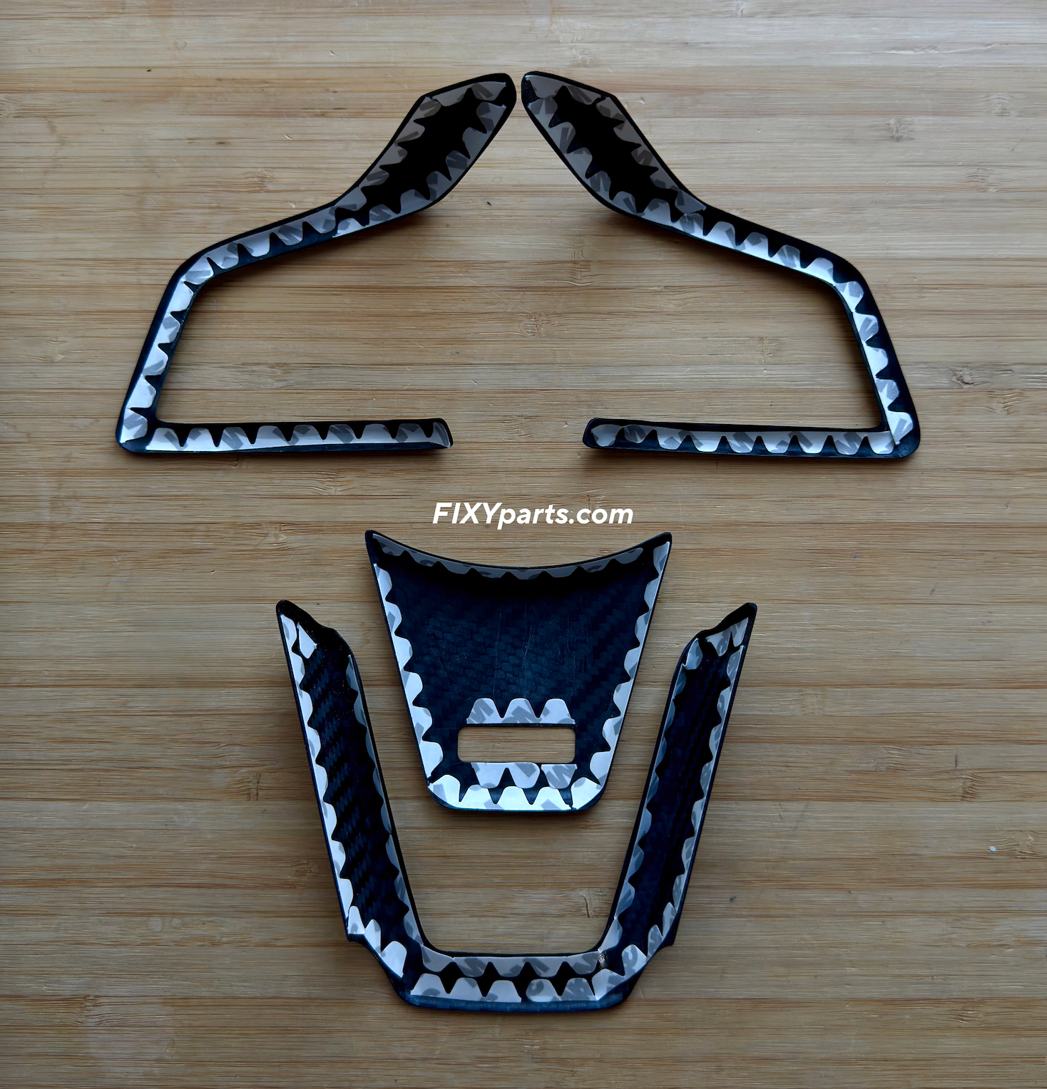 Black and silver car parts on a wooden surface with 'FIXYparts' branding.