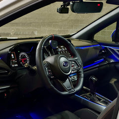 Car interior with steering wheel and dashboard against a brick wall background
