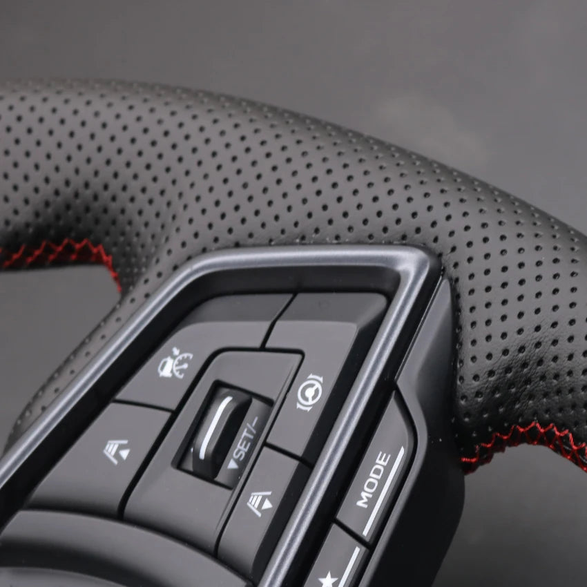 Close-up of a car steering wheel with control buttons on a dark background