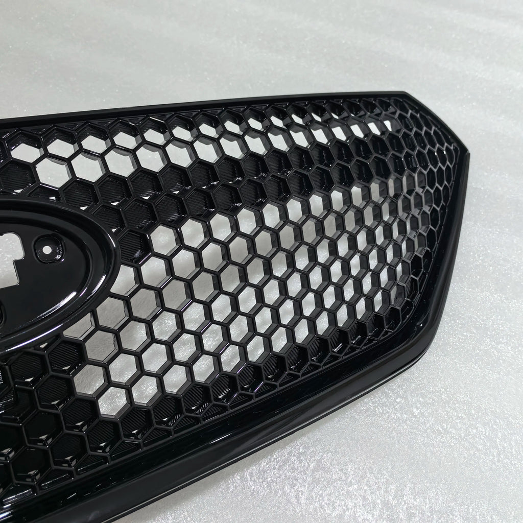 Close-up of a black honeycomb car grille on a light gray background