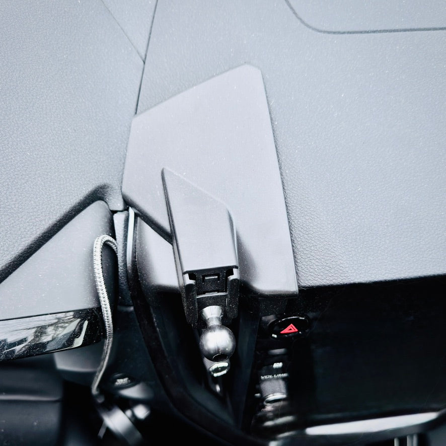 Close-up of a car's interior with a side mirror and dashboard.
