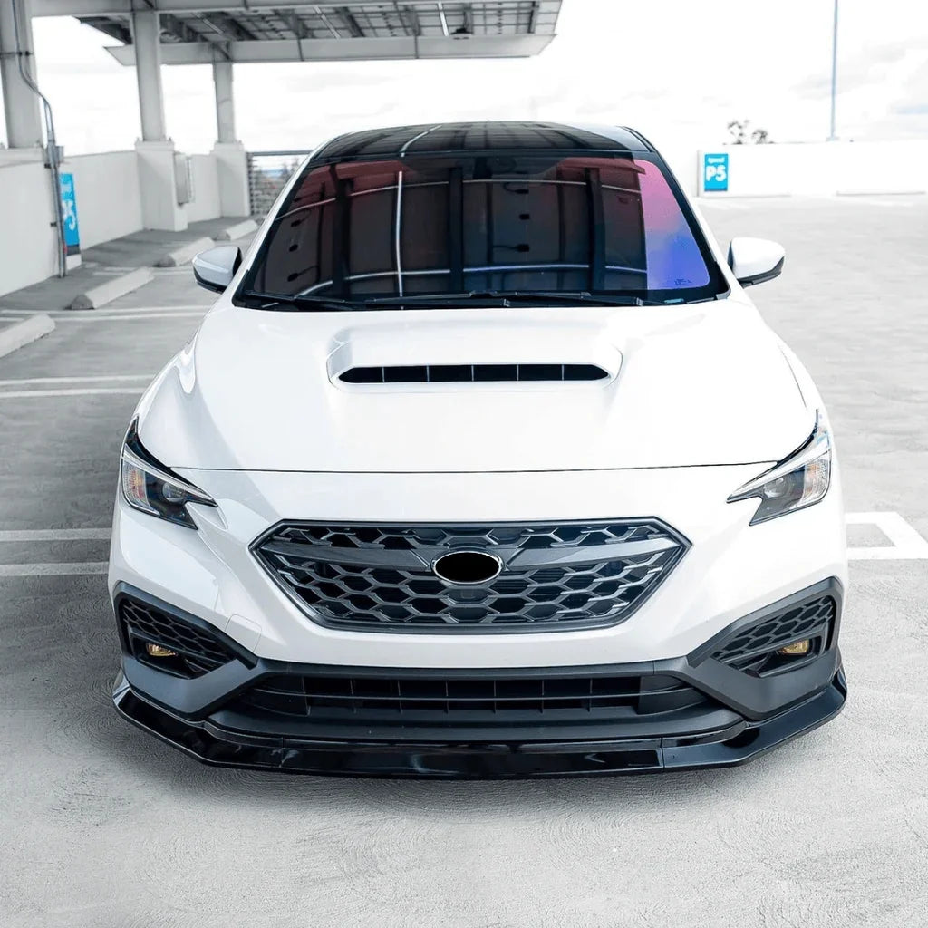 White Subaru car with a black grille in a parking lot