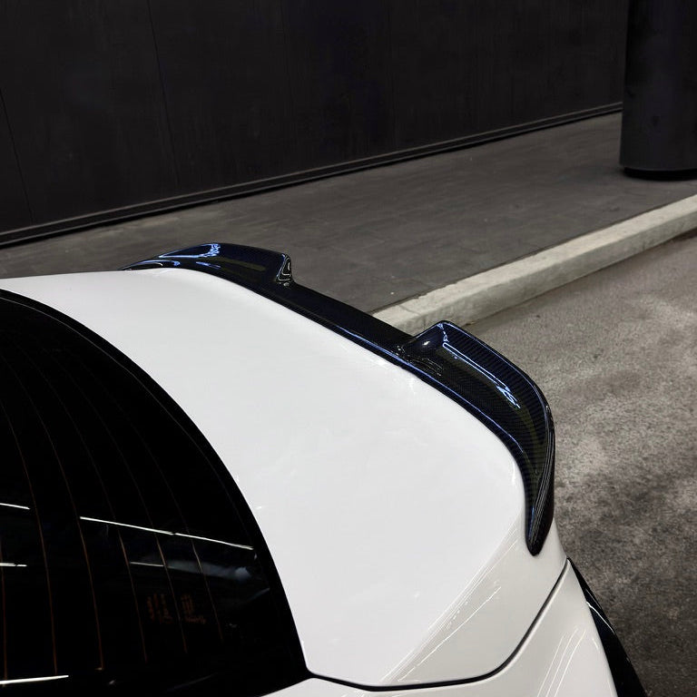 Close-up of a car's rear spoiler on a white car with a black background