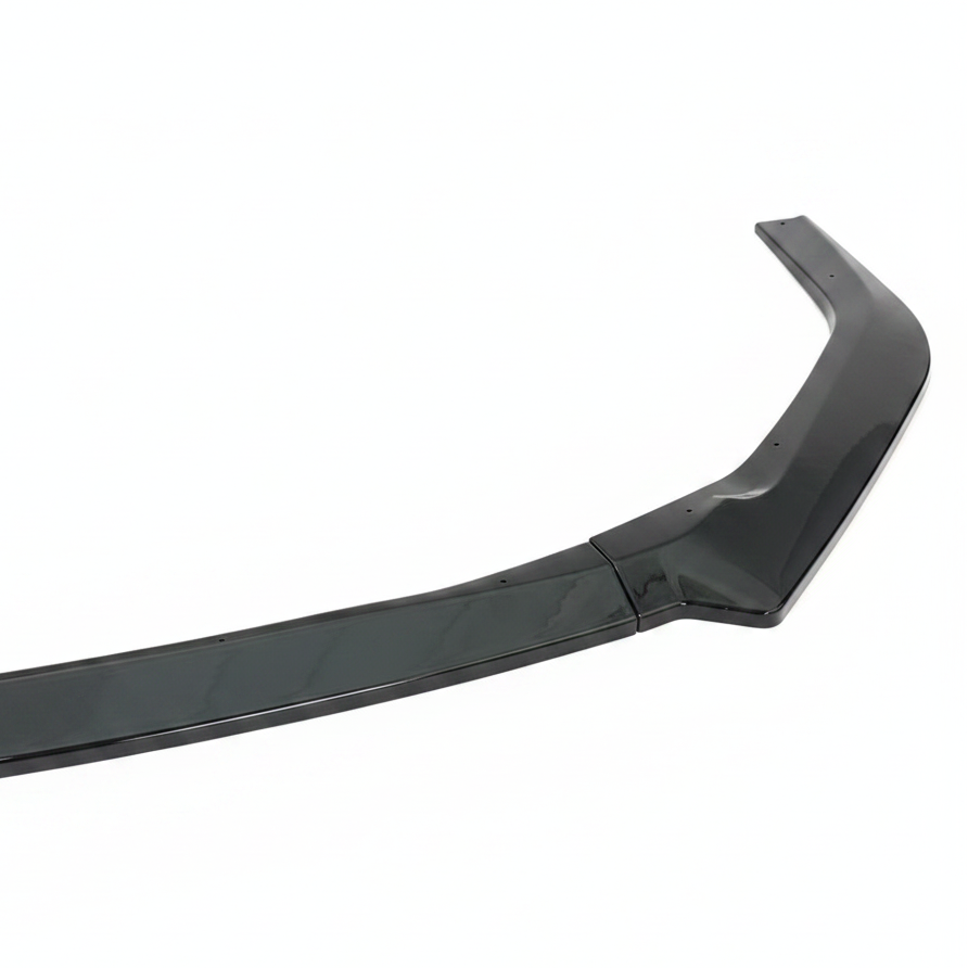 A glossy black automotive trim piece, likely a lip spoiler or side molding trim, displayed diagonally on a textured gray fabric background with repeating watermark text.