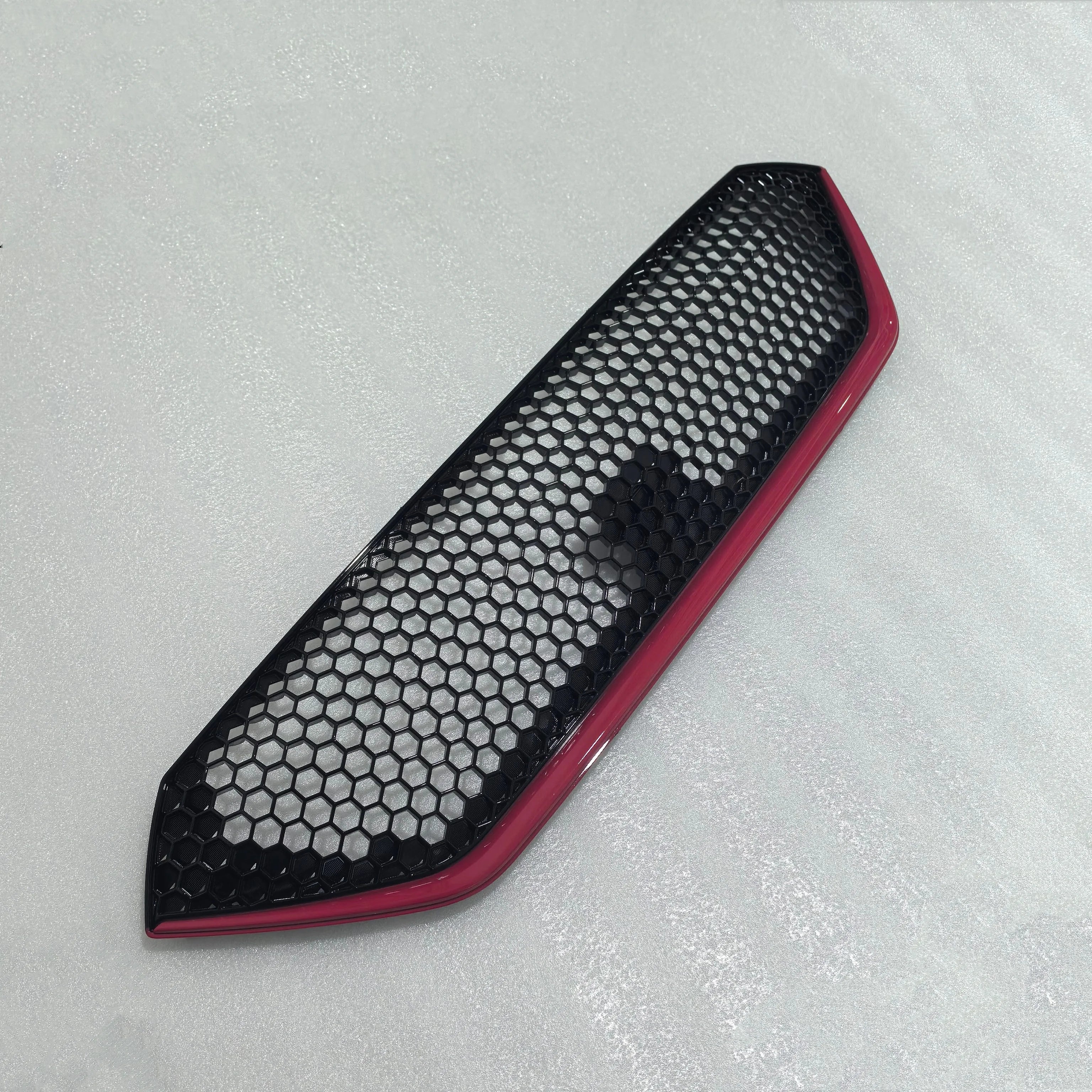 Car air vent with honeycomb design on a gray background