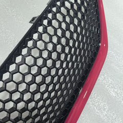 Car grille with honeycomb pattern and red border on a gray background